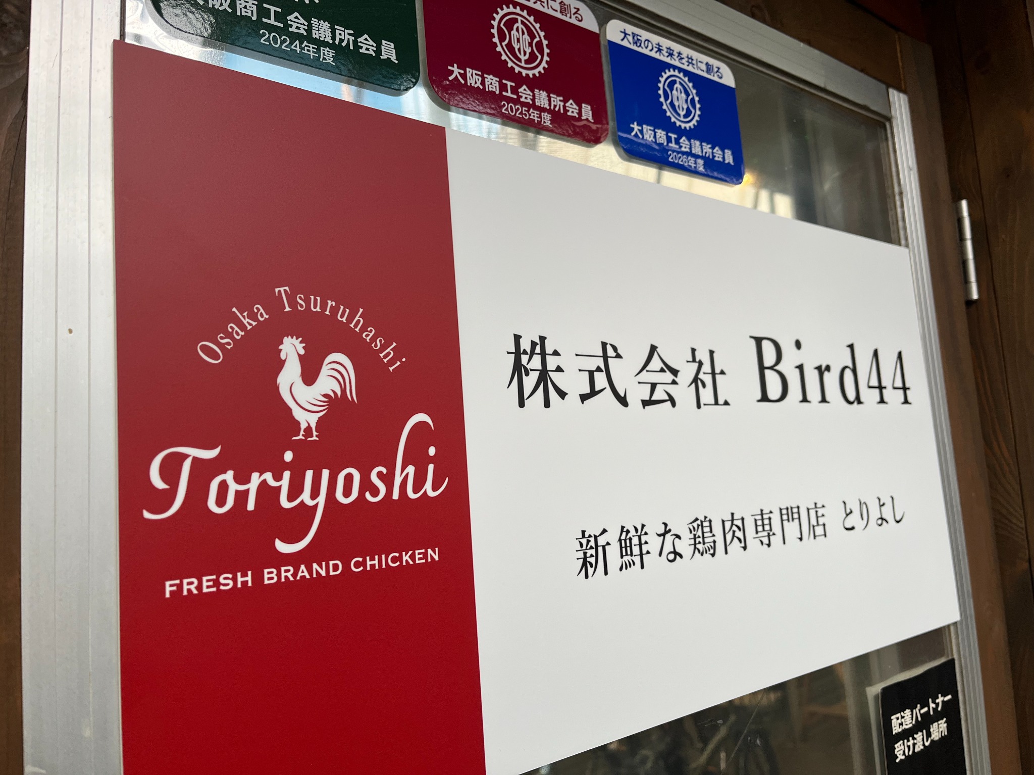 Toriyoshiのロゴと株式会社Bird44の名前が入った、とりよしの看板